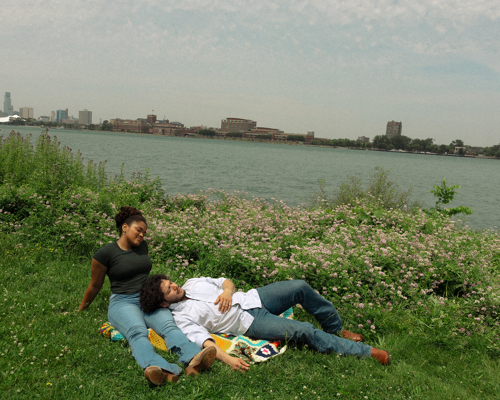 Couple laying in the grass at Belle Isle for their Detroit engagement photos.