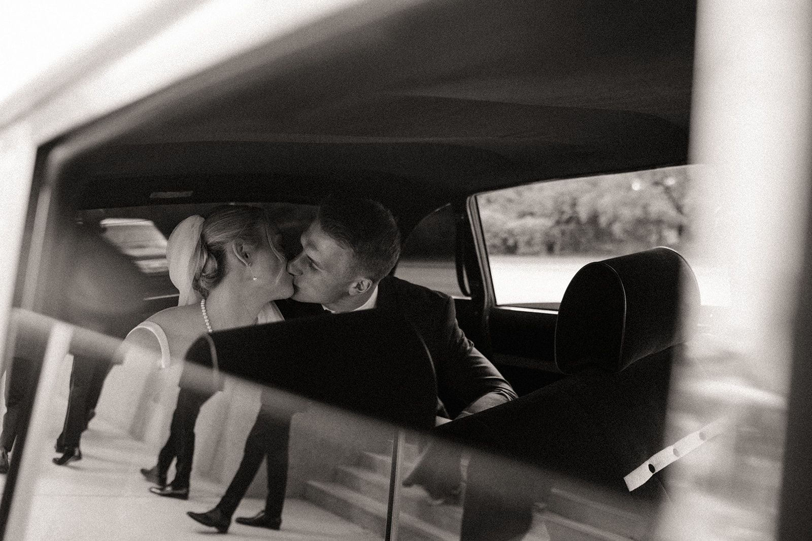 Bride and groom kissing in their petroleum car rental during their Detroit wedding photos