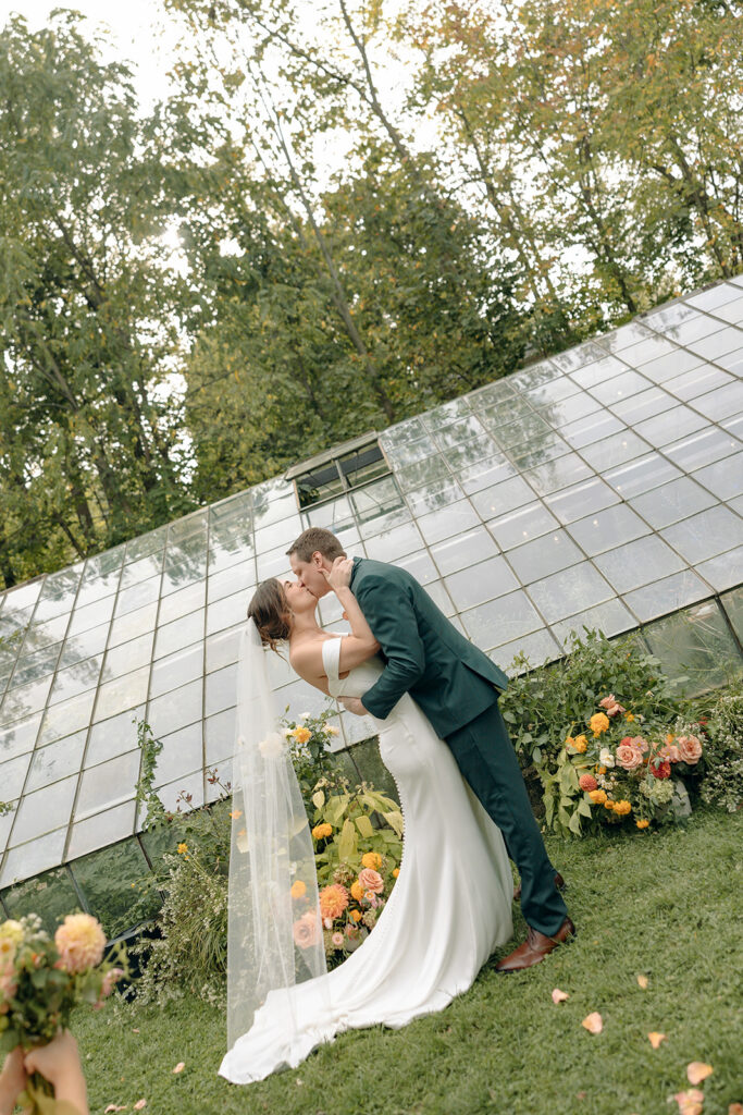 Bride and groom kissing during their outdoor wedding ceremony at Glass House Creative Community in Zeeland, MI