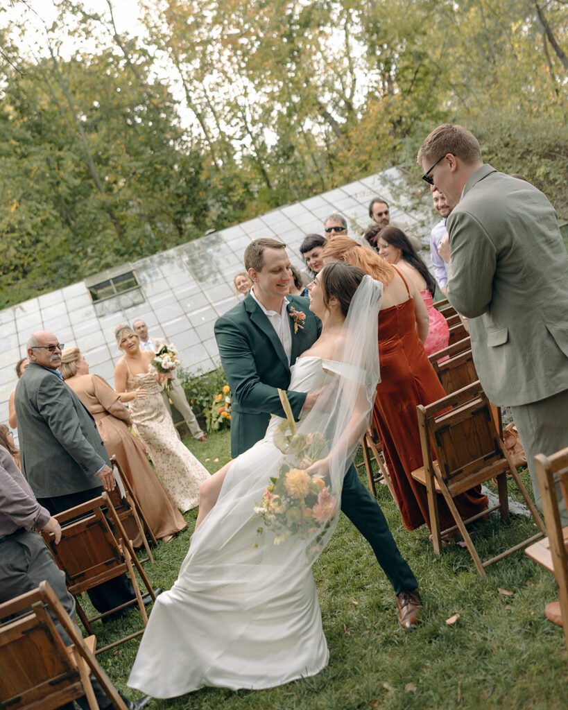 Bride and grooms end of aisle dip kiss at Glass House Creative Community in Zeeland, MI