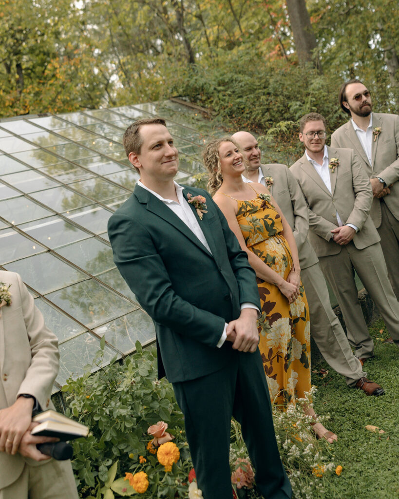 Groom smiling as he sees his bride being walked down the aisle