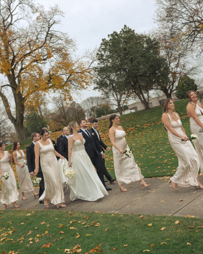 Wedding party walking through a park