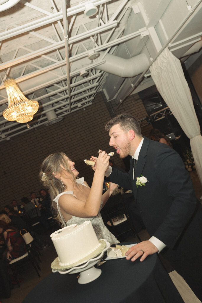 Bride and groom feeding each other cake