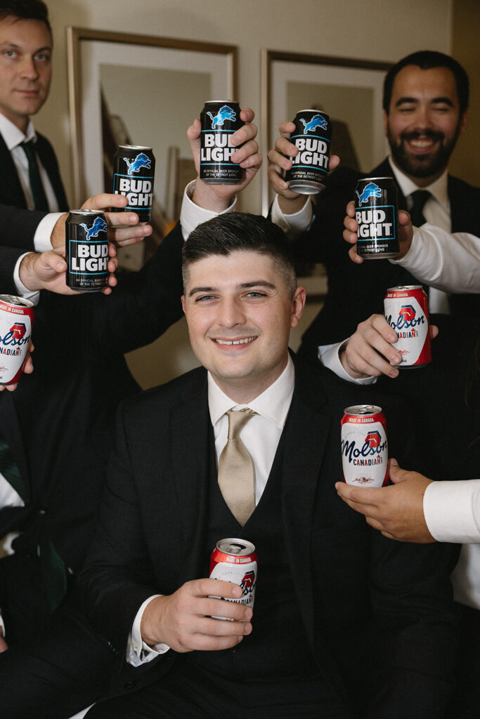 Indoor grooms portraits with a groomsmen beer bouquet