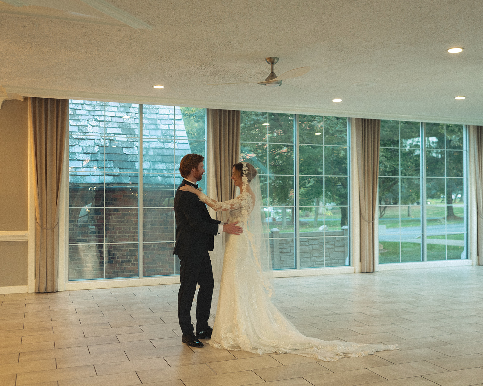 Couple shares private first dance in bright reception space at Pine Knob Mansion