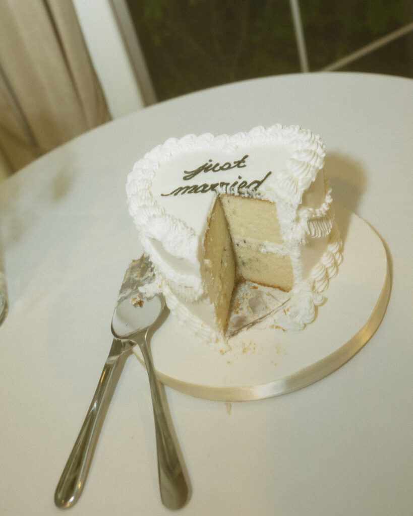 Close-up of a heart-shaped 'just married' cake on a white table at a wedding reception