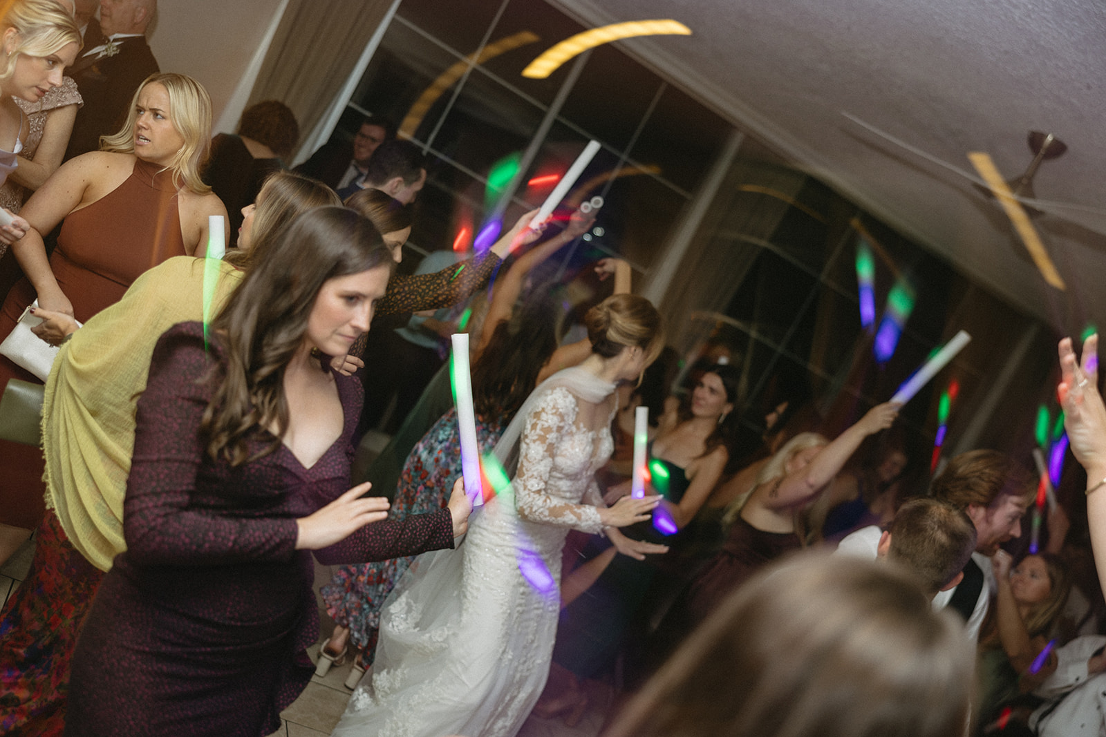 Guests dancing with glow sticks during a lively wedding party