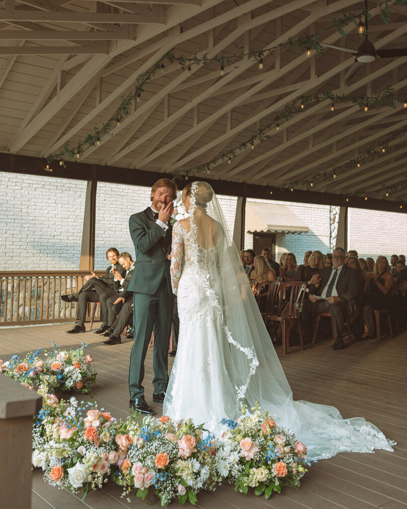 Bride and groom exchanging vows during their Pine Knob Mansion wedding ceremony in the Carriage House