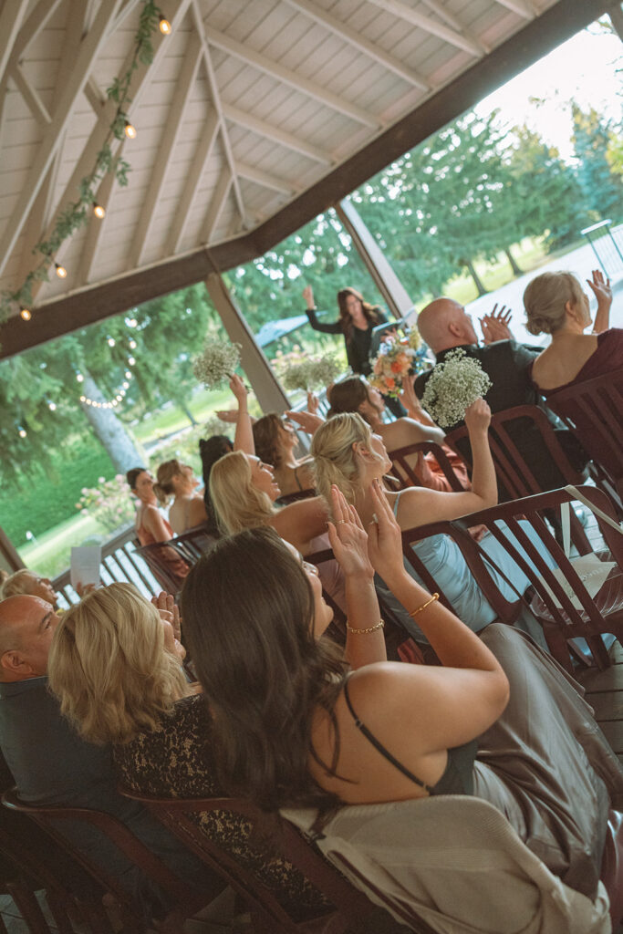 Guests clapping during a Pine Knob Mansion wedding ceremony in the Carriage House
