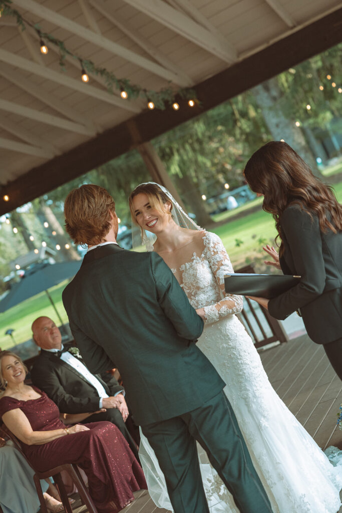 Bride and groom holding hands during their Pine Knob Mansion wedding ceremony in the Carriage House