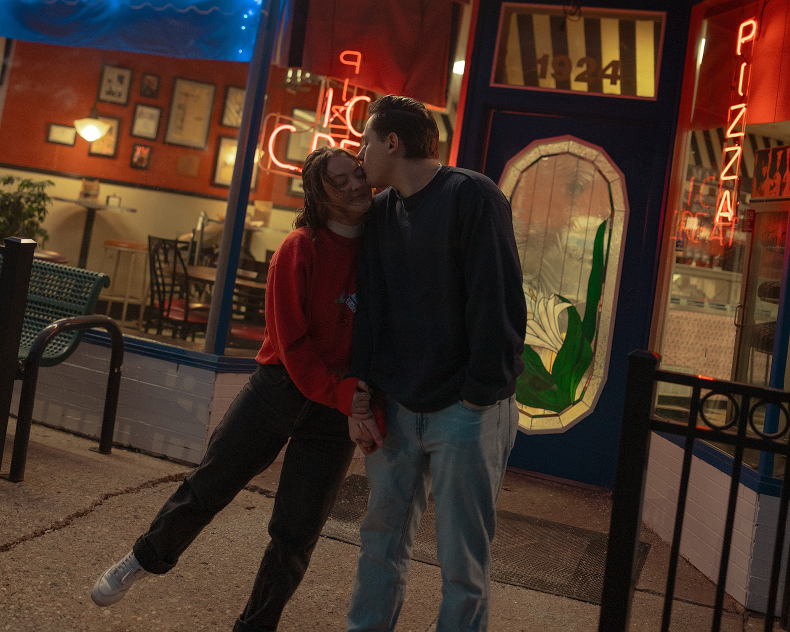 Couple posing outside of a Michigan ice cream shop for their engagement session
