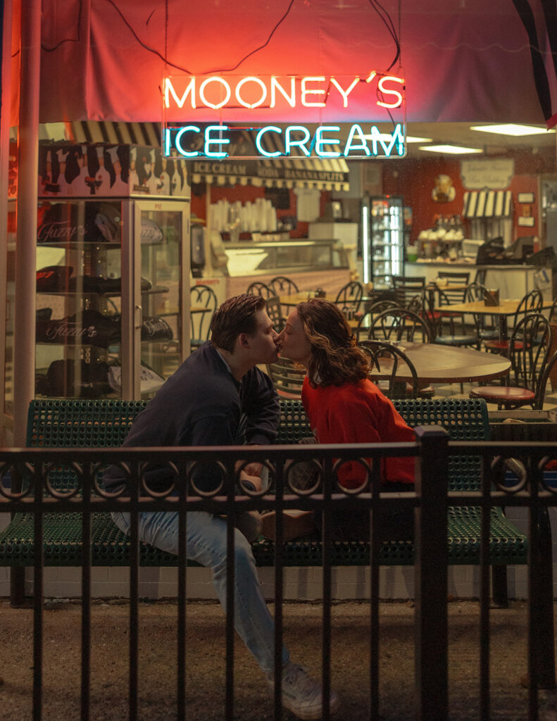 Couple kissing in front of Mooney's Ice Cream Shop in Michigan
