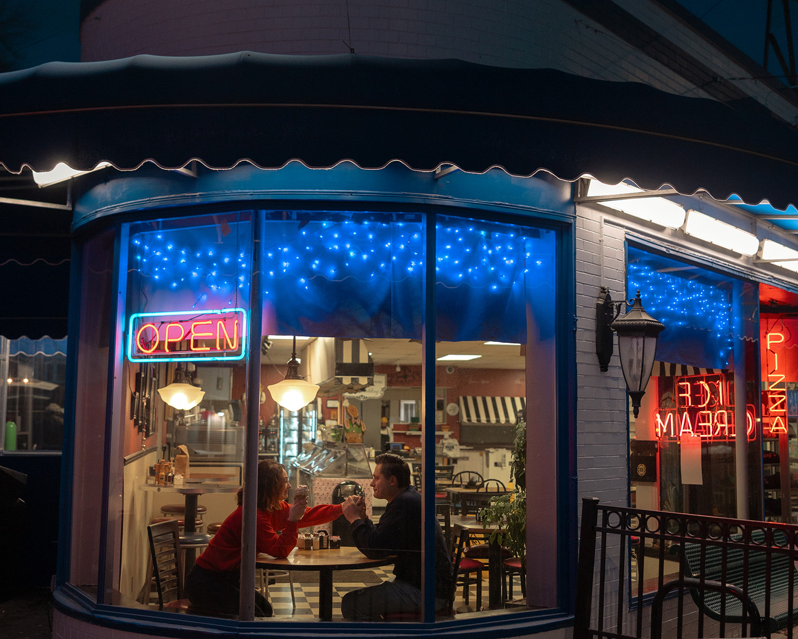 Couple sitting inside of an ice cream shop for their engagement shoot