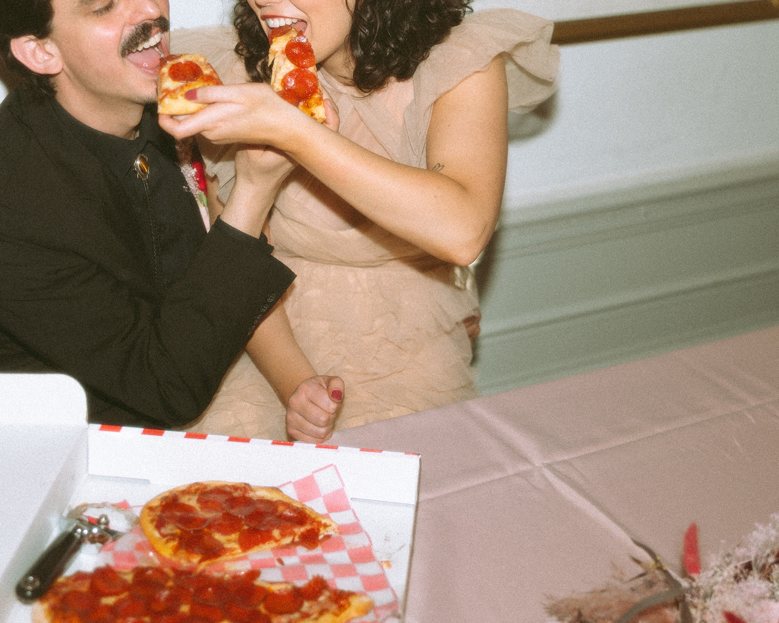 Bride and groom feeding each other slices of pizza during their Grand Rapids, Michigan elopement