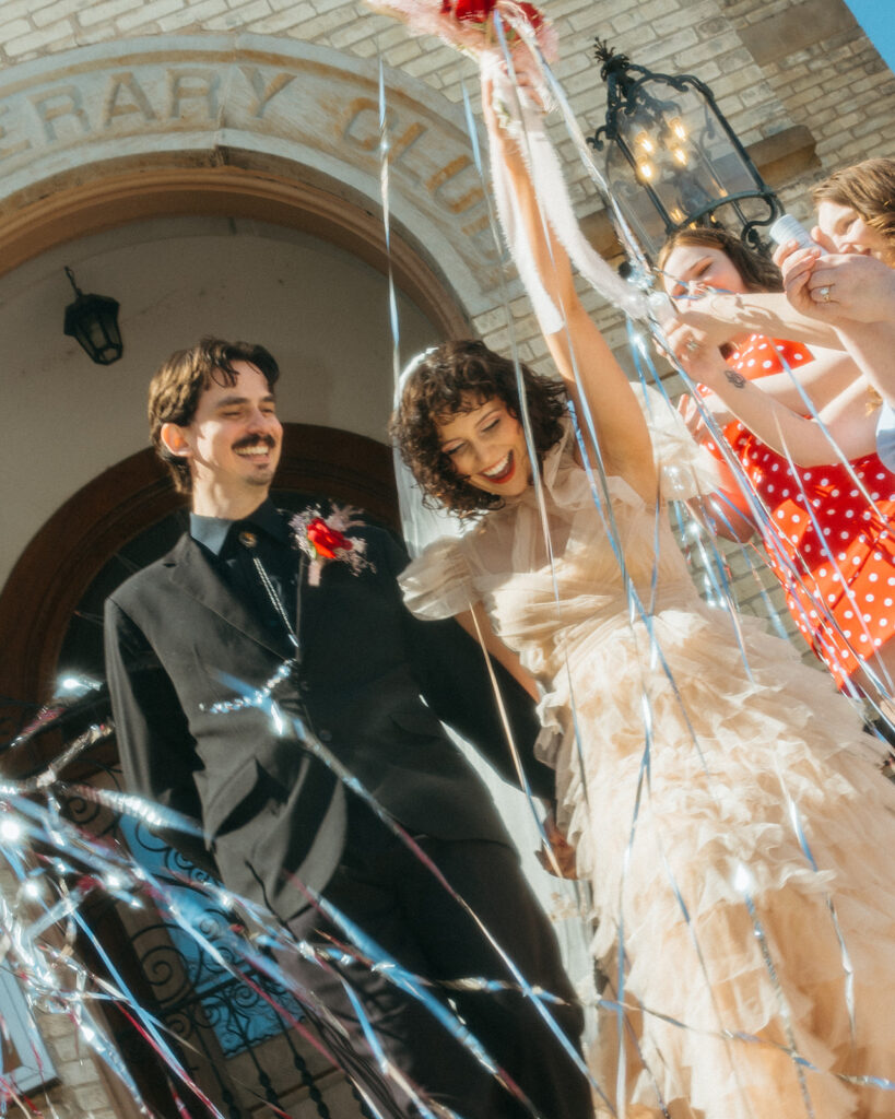 Couple walks through a fun streamer sendoff capturing the energy of their unique Michigan elopement.