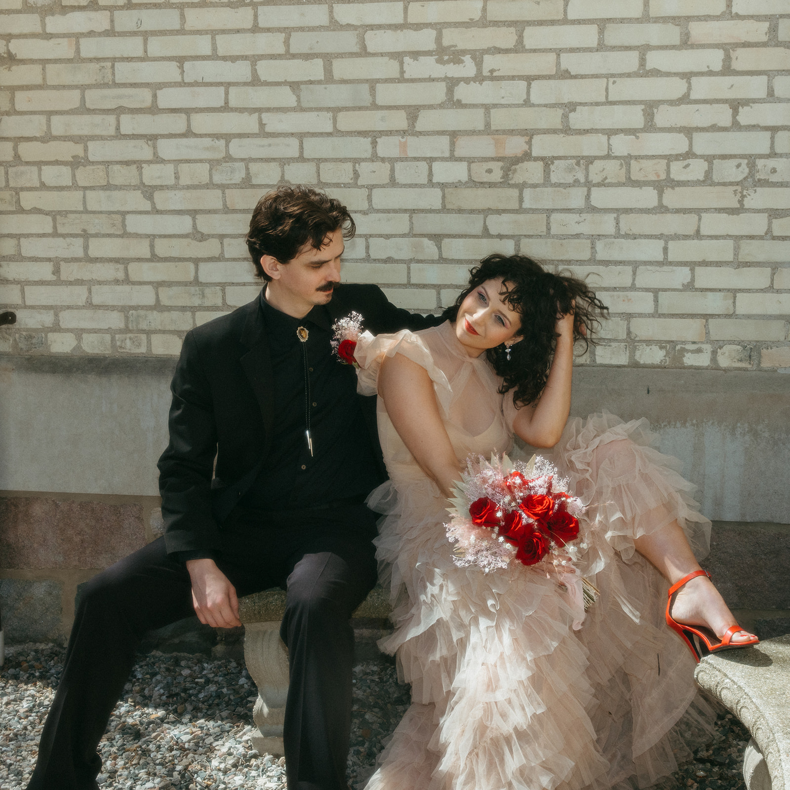 Groom embracing bride as she leans into him with bouquet, romantic Michigan elopement