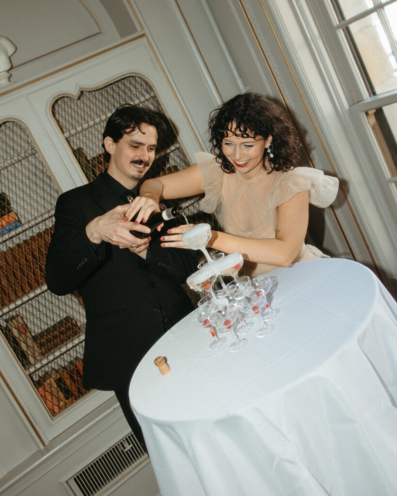 Bride and groom pouring into their champagne tower