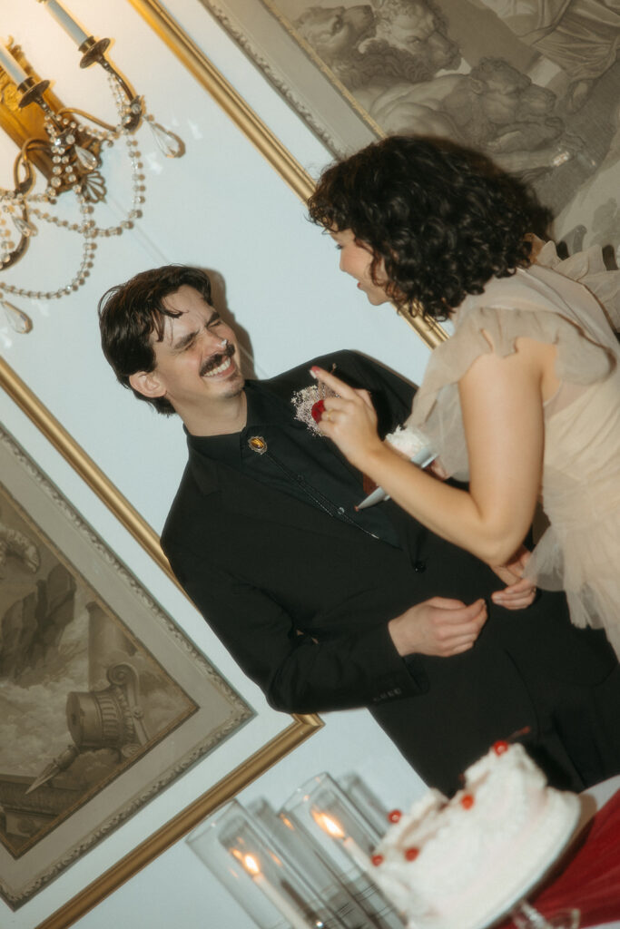 Bride and groom digging into their elopement cake