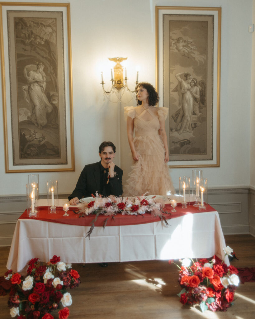 Bride and groom posing for photos at their sweethearts table