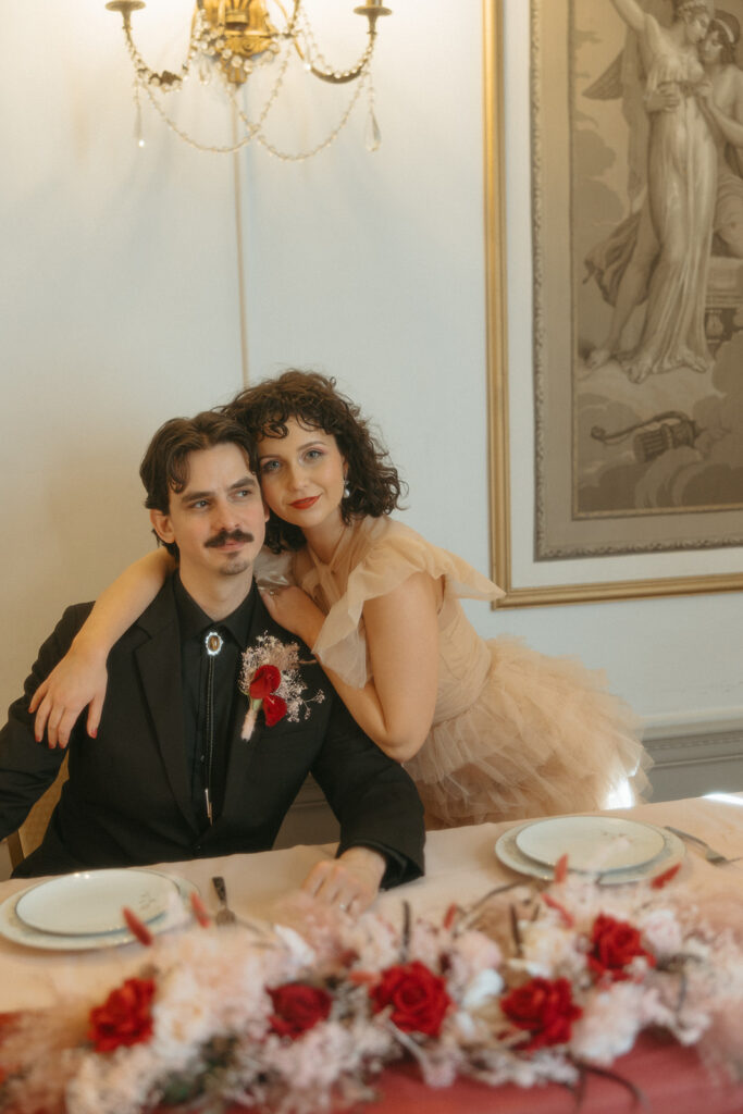 Bride and groom posing at their sweethearts table for their intimate Michigan elopement reception