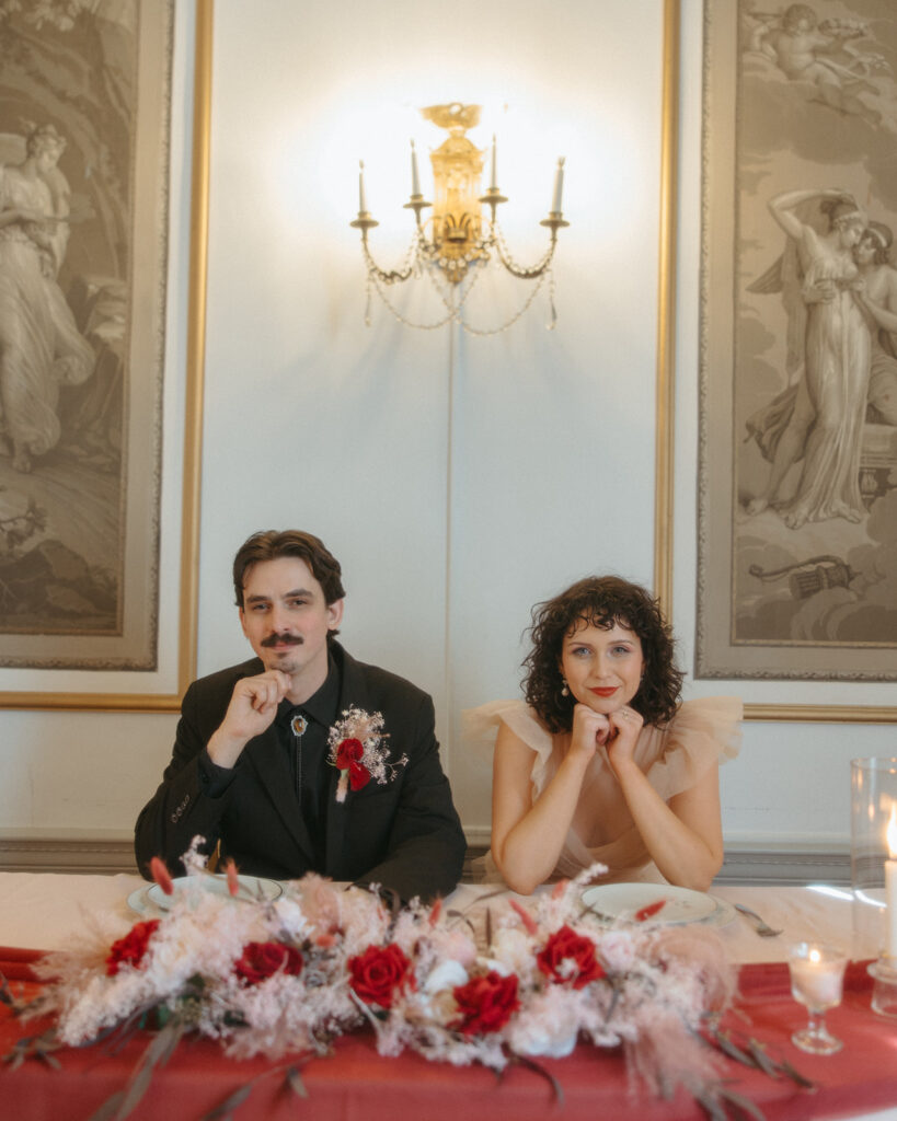 Bride and groom posing at their sweethearts table for their intimate Michigan elopement reception