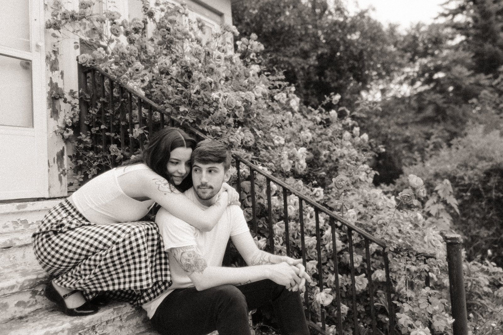 Black and white photo of a couple posing for their outdoor engagement photos