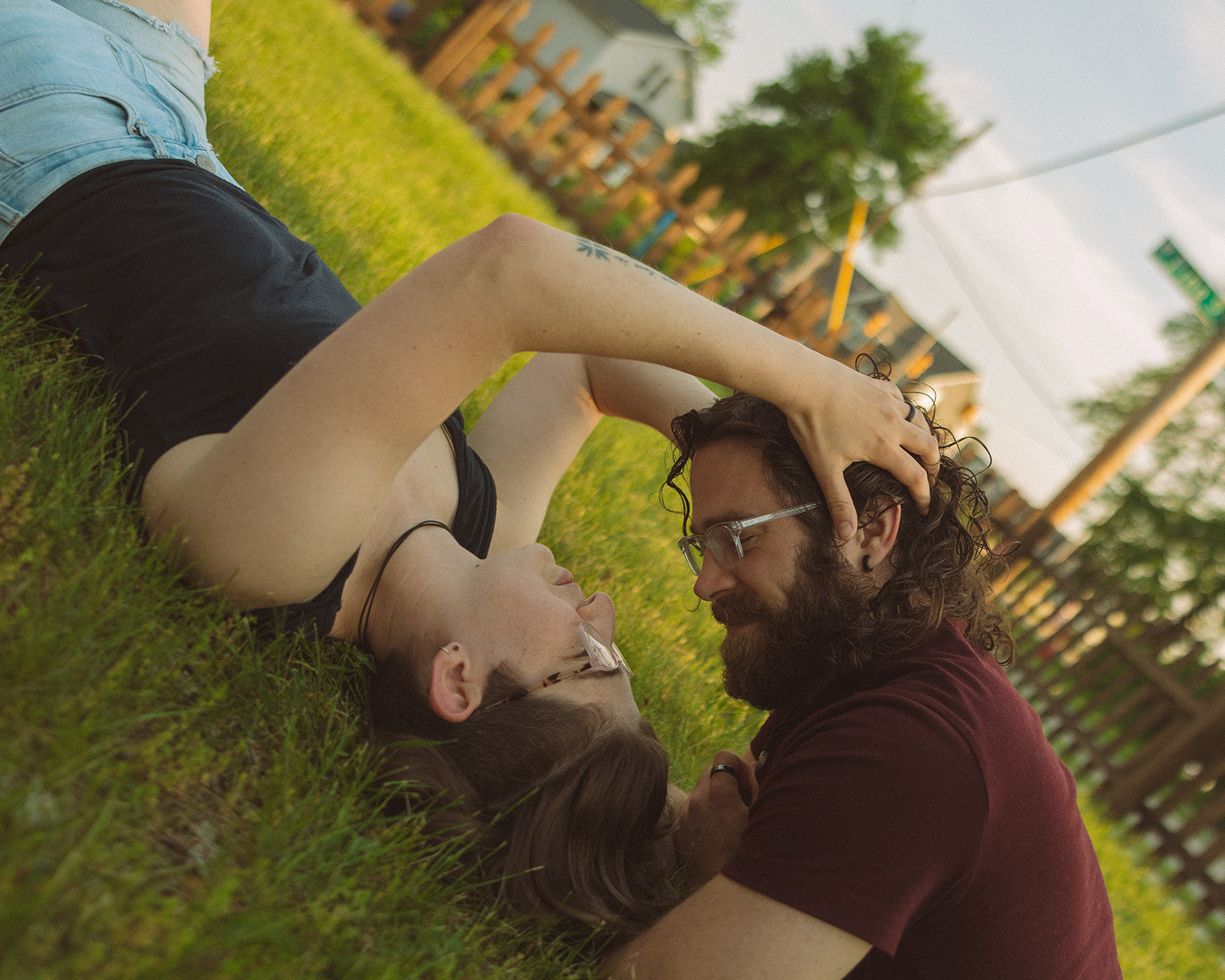 Couple laying in the grass for their casual outdoor engagement photos in Michigan