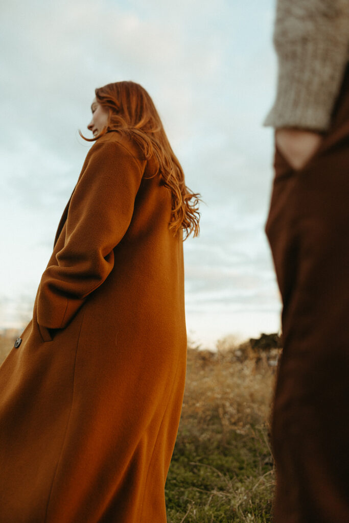 Couple walking through a field for their fall engagement photos in Detroit