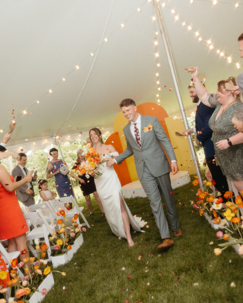 Bride and groom walking back down the aisle as husband and wife after their backyard wedding ceremony - Unique Wedding Venues in Michigan