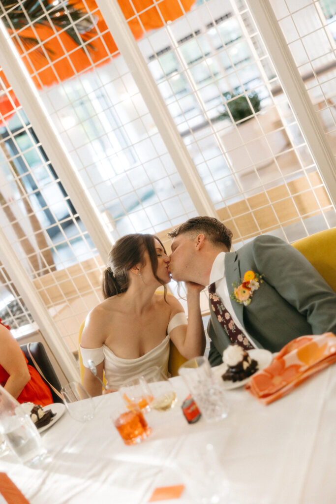 Bride and groom kissing during their colorful Venue by 4M reception in Michigan - Unique Wedding Venues in Michigan