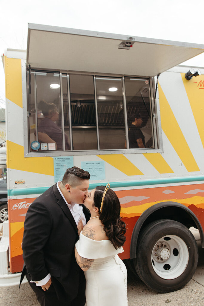 Couple kissing in front of a taco truck