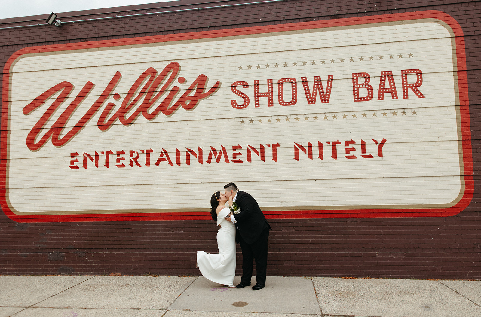 Couple kissing in front of Willis Show Bar in Detroit, Michigan - Unique Wedding Venues in Michigan