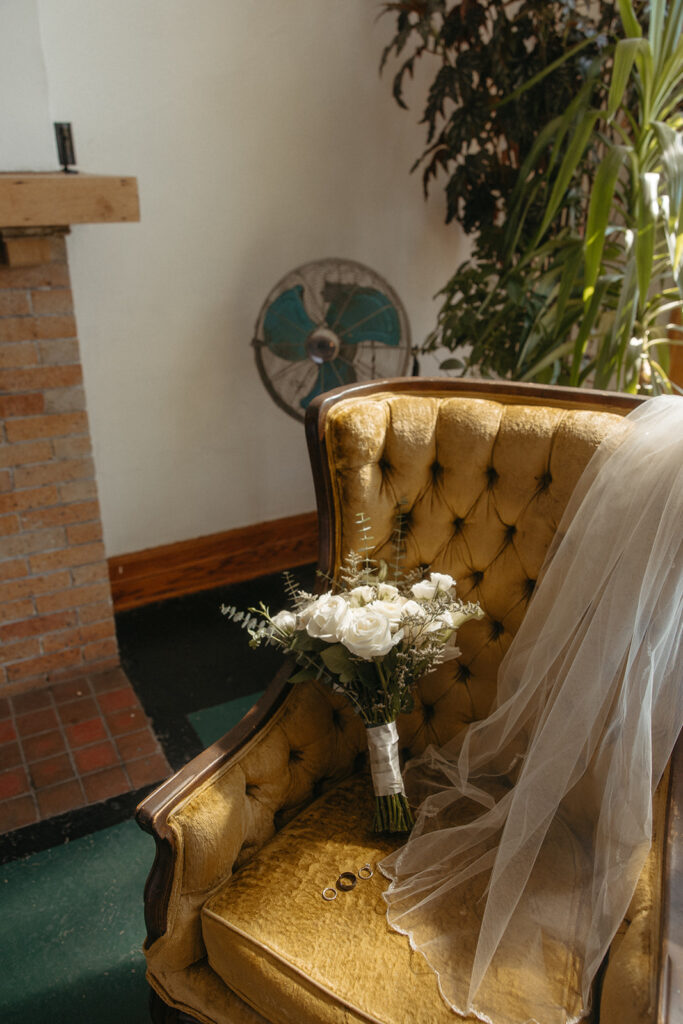 Brides bouquet sitting on a vintage chair at Jam Handy wedding venue in Detroit, Michigan