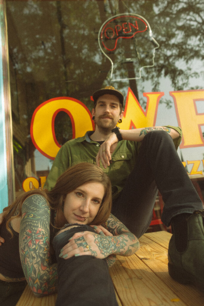 Close up photo of a couple cuddling together at a picnic table