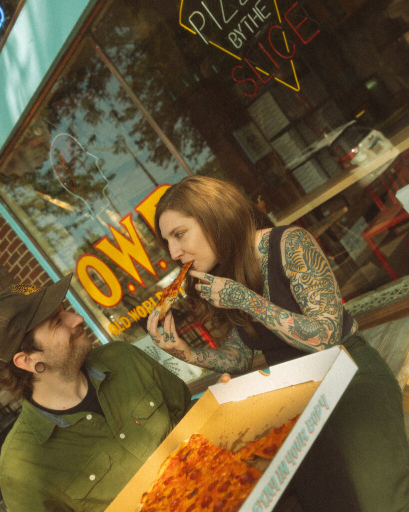 Couple eating pizza outside of Old World Pizzeria in Saginaw, Michigan for their casual low-key engagement session.