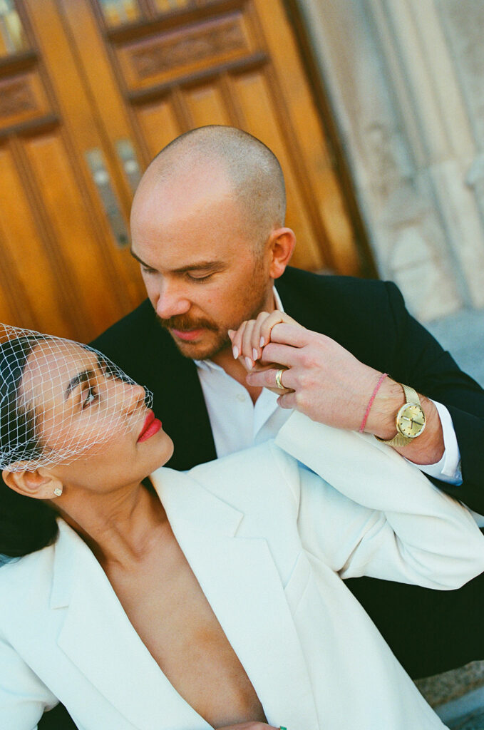 Close up shot of a couple sitting in the steps outside of  Birmingham City Hall.