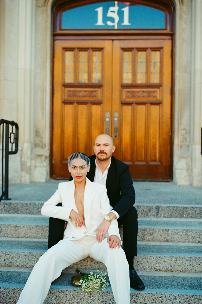 Editorial Detroit elopement photos of a couple sitting on the steps outside of Birmingham City Hall.