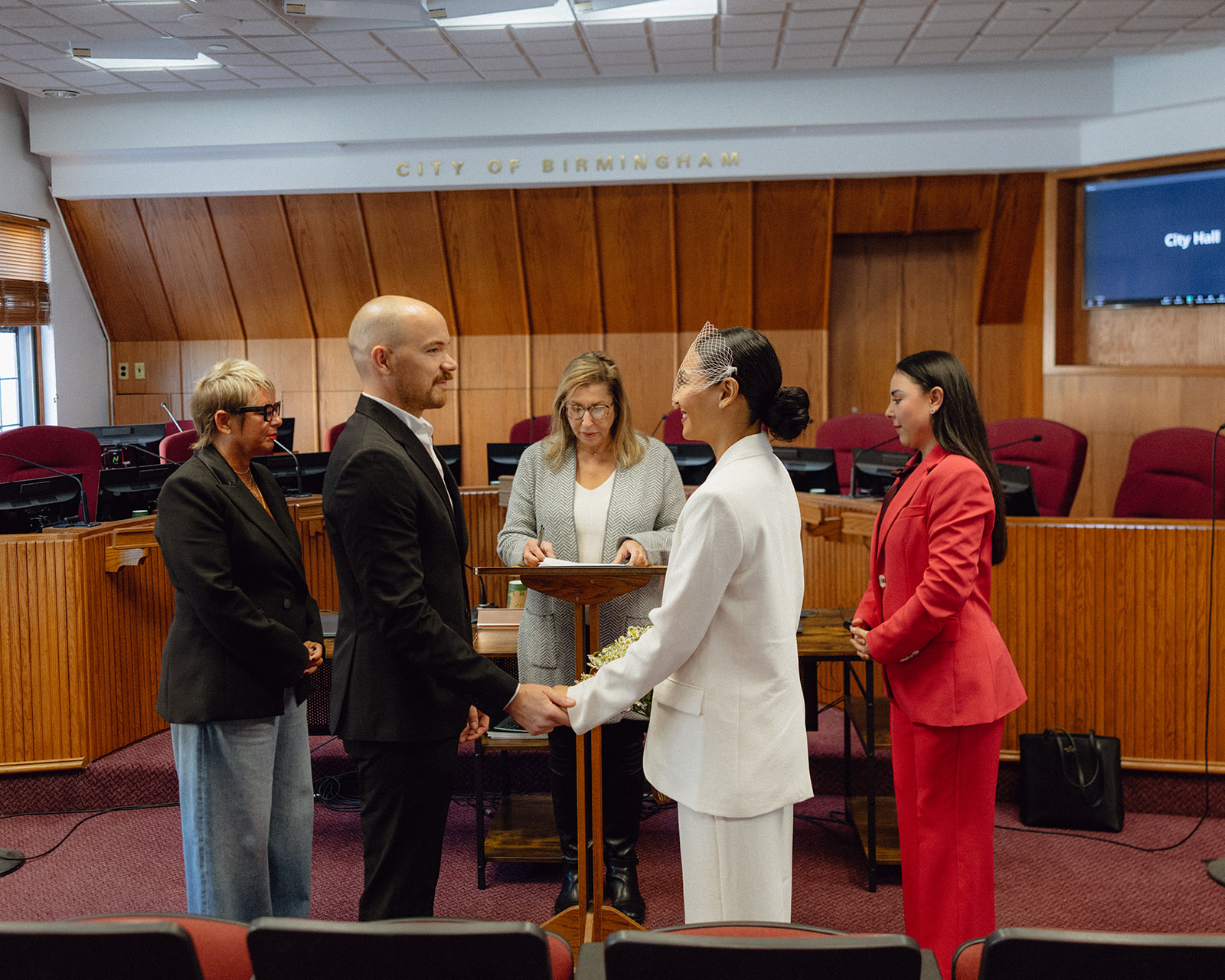 Couple holding hands during their Birmingham City Hall elopement in Michigan. 