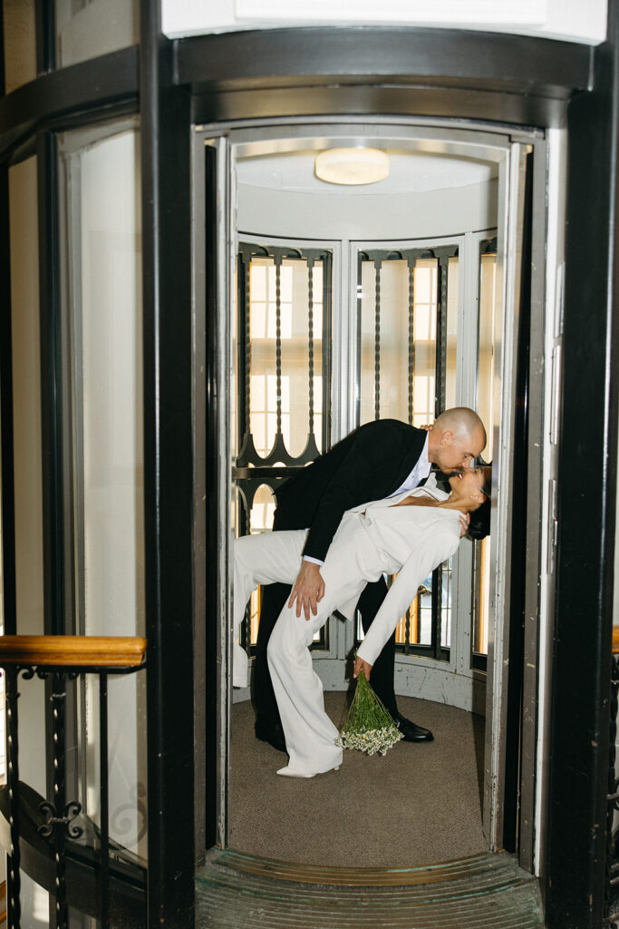 Romantic elevator dip portrait of couple inside Birmingham City Hall after their ceremony.