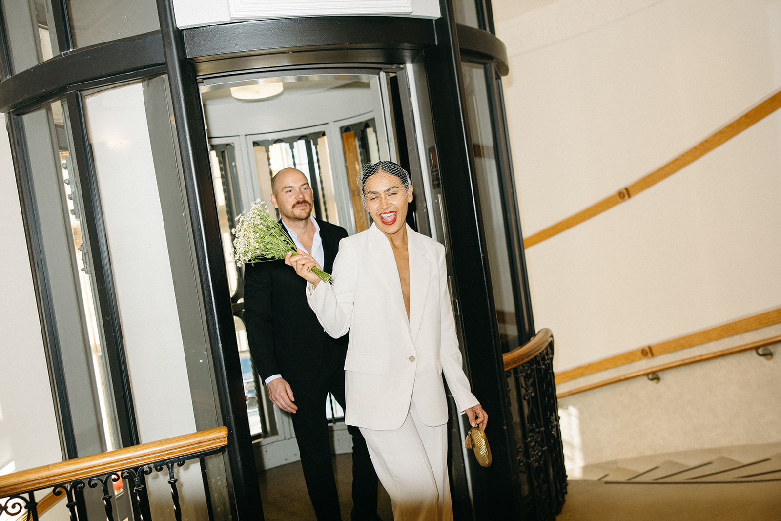 Couple walking out of an elevator at the Birmingham City Hall.
