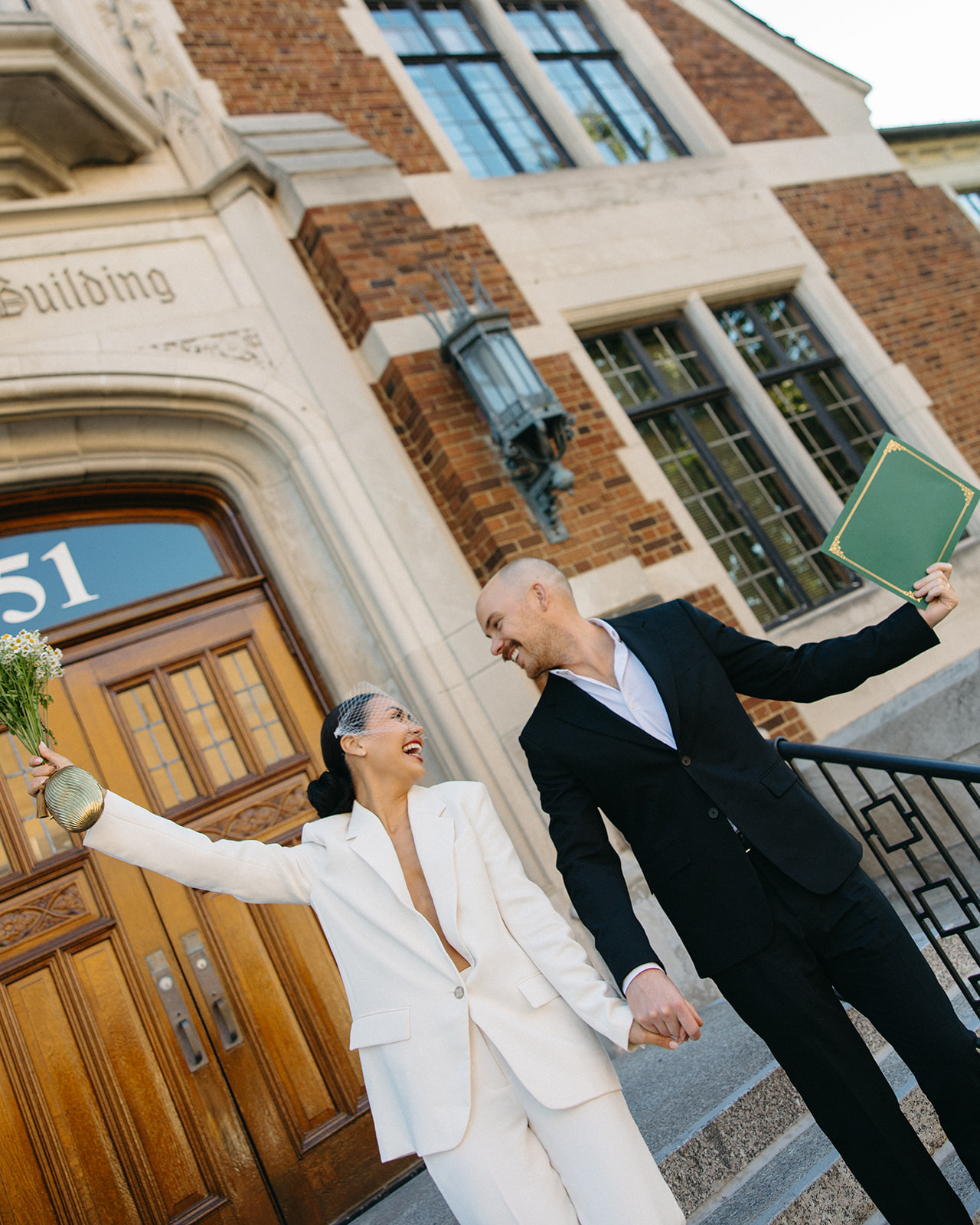 Newlyweds walking out of Birmingham City Hall doors following their intimate elopement ceremony.