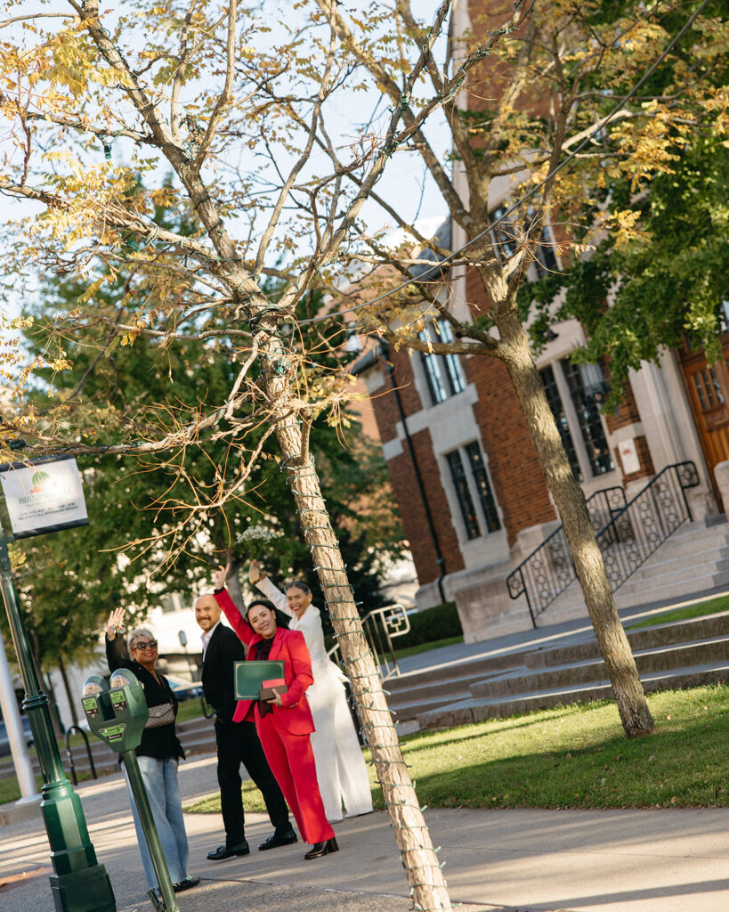 Couple with witnesses celebrating outside Birmingham City Hall following their elopement.
