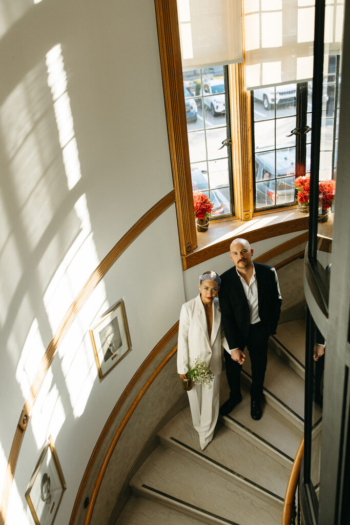 Couple standing on a winding staircase inside Birmingham City Hall during elopement portraits.