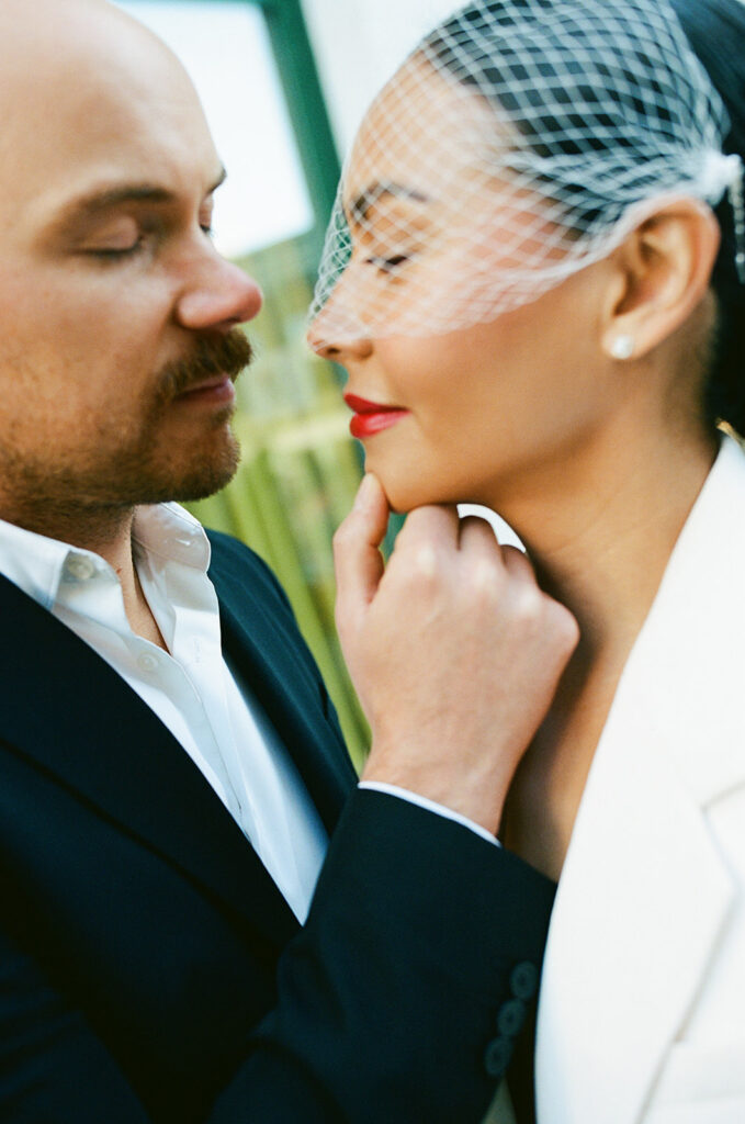 Close up photo of a bride holding the brides chin during their Detroit film elopement photos. 