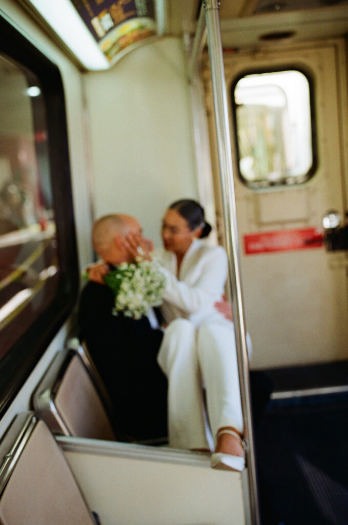 Woman sitting on the grooms lap as they ride the Detoit People Mover captured on film. 