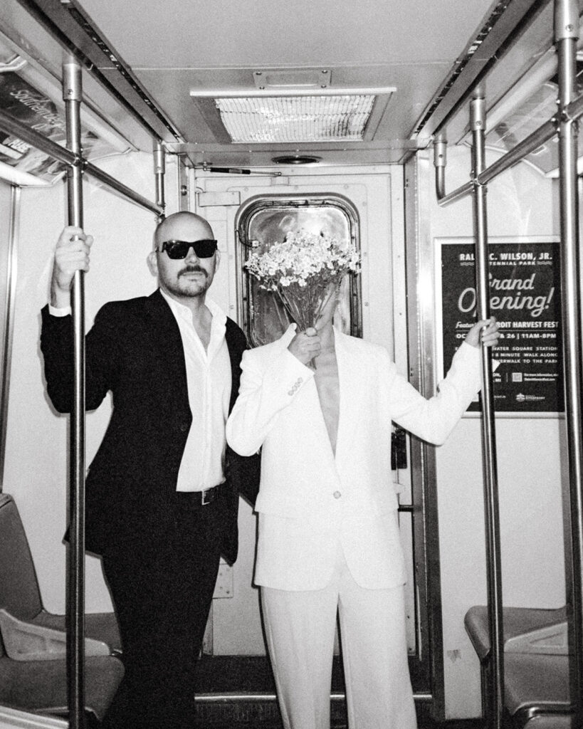 Editorial Detroit elopement photo of a couple posing on the Detroit People Mover. 