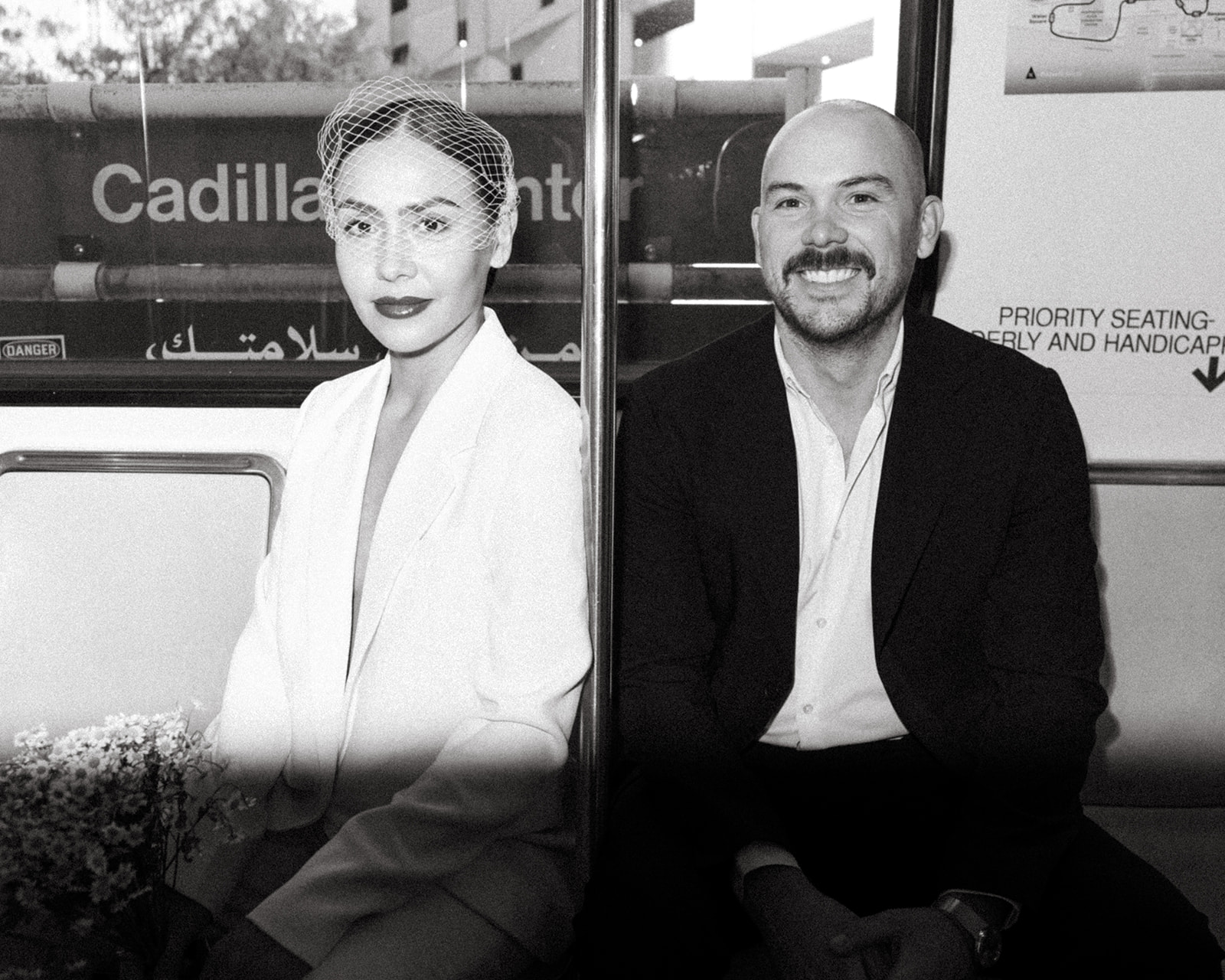 Black and white portrait of couple seated on the Detroit People Mover during their elopement.