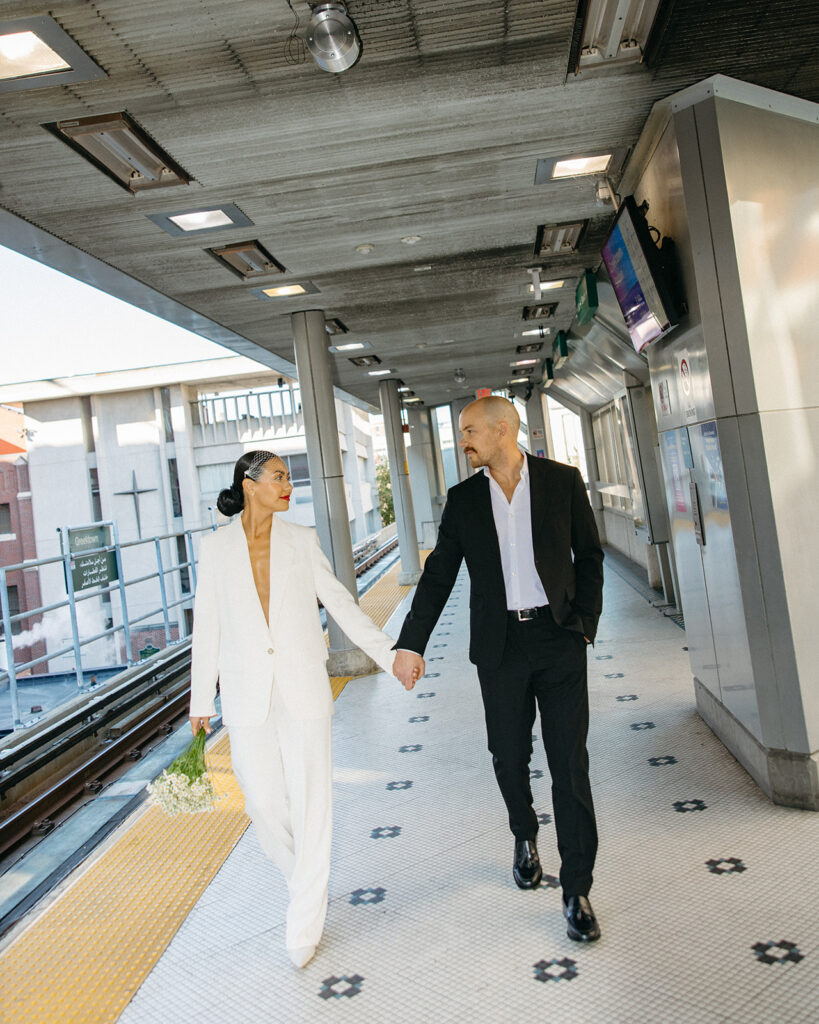 Couple holding hands on the People Mover platform in downtown Detroit.