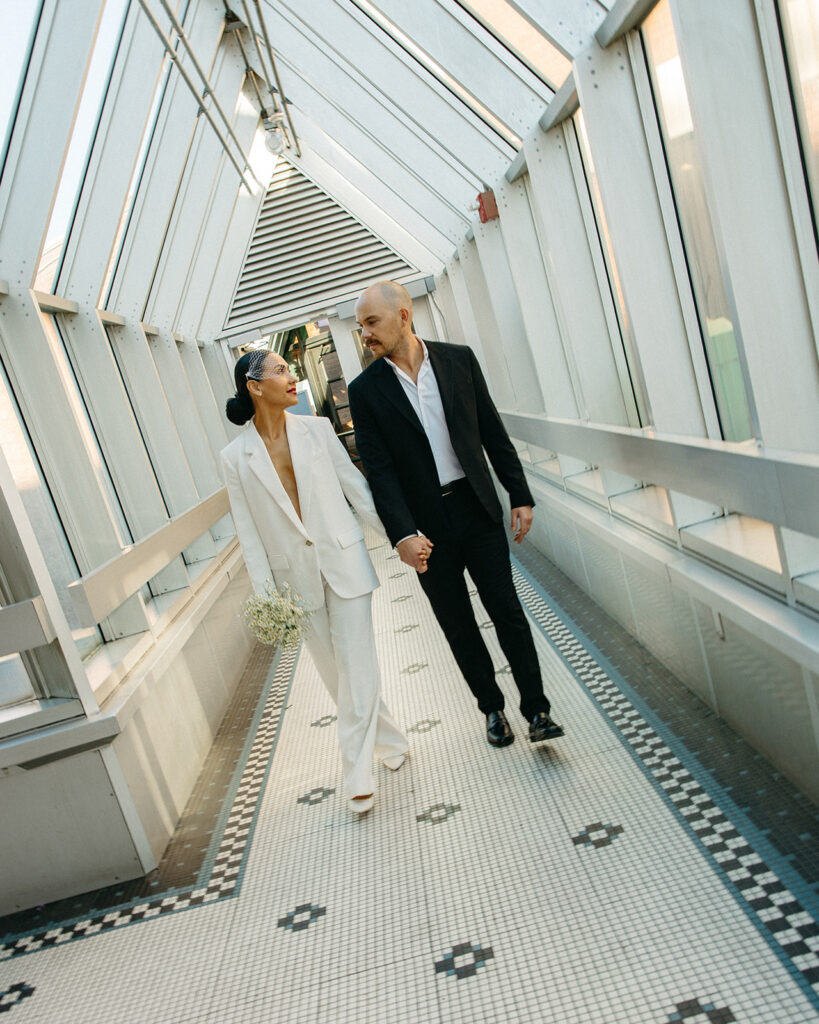 Couple holding hands and walking together during their Detroit elopement photos. 