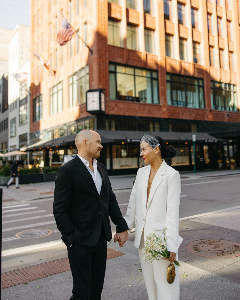Couple holding hands in downtown Detroit for their elopement photos.